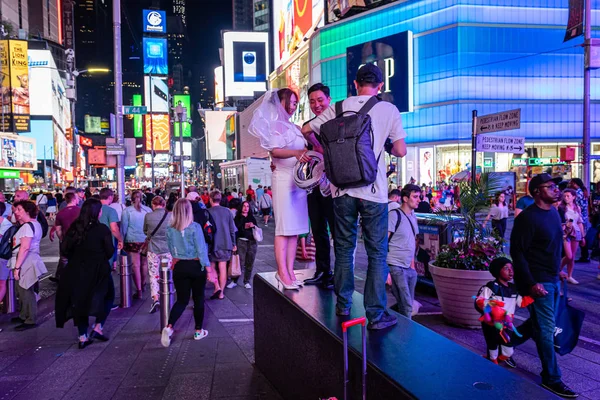 Nueva York, Estados Unidos - 21 de junio de 2019: multitudes de personas y recién casados a la luz de la noche en Times Square . —  Fotos de Stock