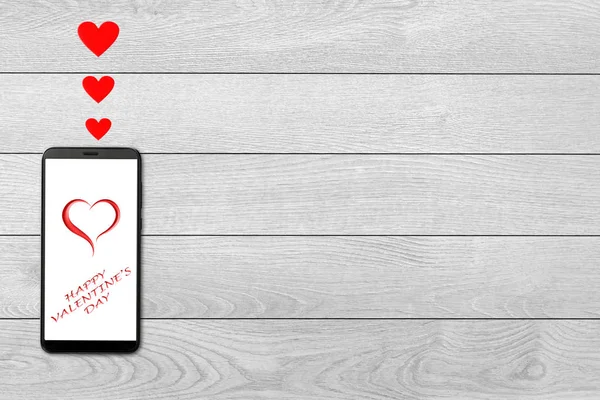 Conceito de dia dos namorados, mensagem de amor corações voando para fora smartphone, isolado no fundo de madeira branca — Fotografia de Stock