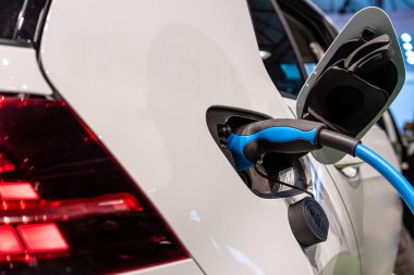 Elektrikli araba şarjı için güç kaynağı. Elektrikli araba şarj istasyonu. Şarj edilen bir elektrikli arabaya takılan güç kaynağını kapatın.