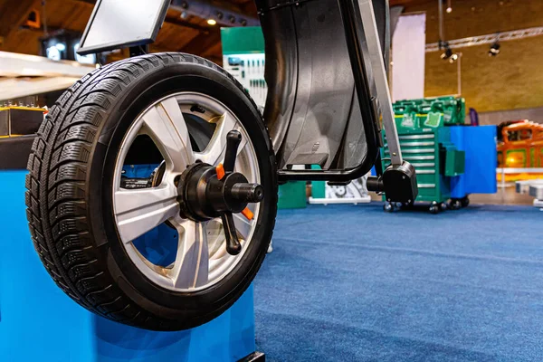 A car wheel on an automated car wheel balance machine in the garage