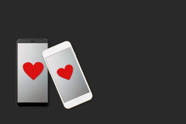 На темном фоне изолированы два смартфона с сердцами на экране, современный гаджет любовь и отношения, любовные послания, День святого Валентина концепции — стоковое фото