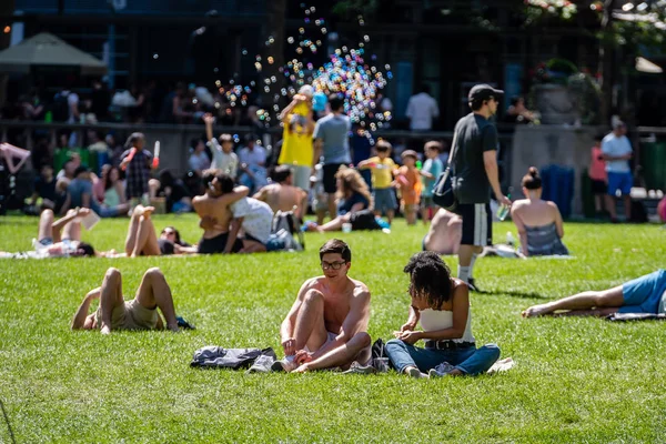 New York, Usa - 23 Haziran 2019: Sıcak bir yaz gününde, insanlar şehir merkezindeki bir parkta güneşleniyor.