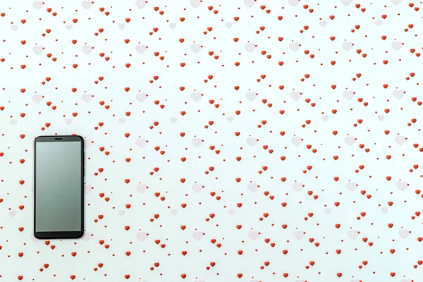 Smartphone avec écran blanc sur fond blanc avec des formes de cœurs colorés. Concept de Saint Valentin, birgtday, cadeau de Noël — Photo