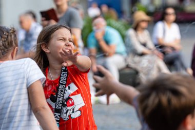 Old Town Square, Riga, Latvia - August 16, 2019: Children playing with colorful soap bubbles floating in the foreground