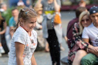 Old Town Square, Riga, Latvia - August 16, 2019: Children playing with colorful soap bubbles floating in the foreground