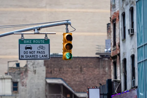 Traffic light with red light above Manhatan street among many skyscrapers, New York, USA