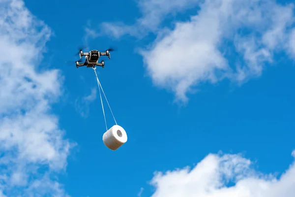 無人機は顧客へのトイレットペーパーのロールで飛んでいますドローンの配達の概念 — ストック写真