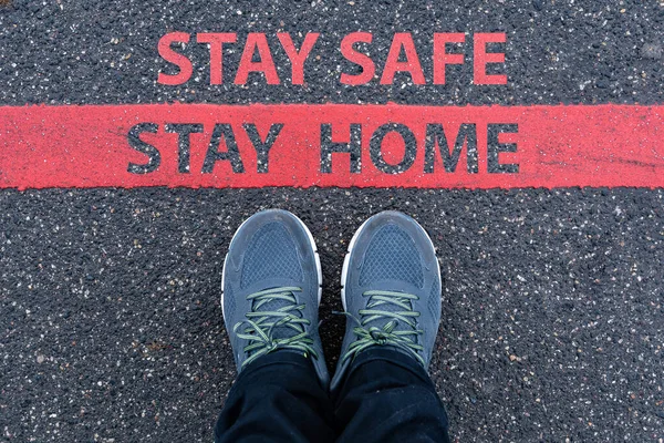 Mężczyzna Trampkach Stojący Obok Czerwonej Linii Tekstem Stay Safe Stay — Zdjęcie stockowe