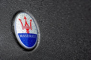 Londra, İngiltere, İngiltere - 31 Aralık 2019: Maserati araba şirketinin yağmur damlalarıyla kaplı parlak bir araba üzerindeki trident logosu, Maserati İtalya merkezli lüks bir otomobil üreticisi.