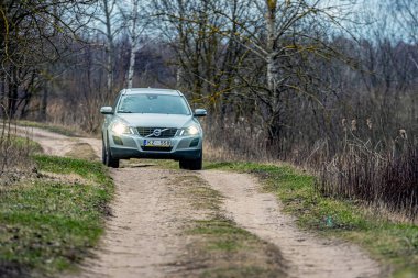 Riga, Letonya - 7 Nisan 2020: İsveçli Volvo XC60 taşralı asfaltsız bir yolda sürüyor, lüks bir aile arabası, ayrıca zor off-road yolculukları için tasarlanmış.