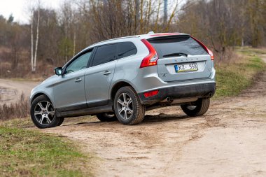 Riga, Letonya - 7 Nisan 2020: İsveçli Volvo XC60 taşralı asfaltsız bir yolda sürüyor, lüks bir aile arabası, ayrıca zor off-road yolculukları için tasarlanmış.