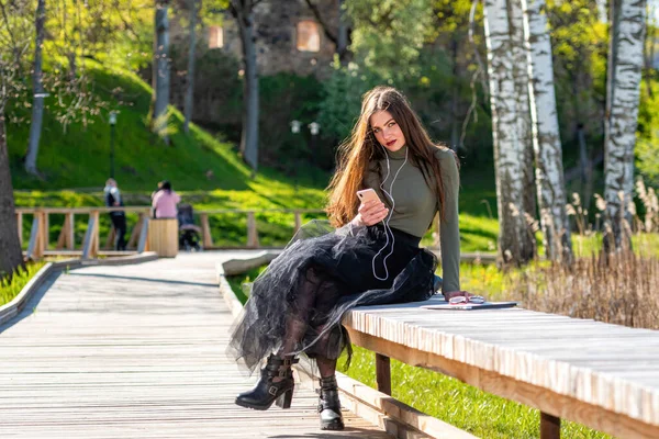 Joven Mujer Sonriente Sentarse Banco Parque Aire Libre Escuchando Música — Foto de Stock