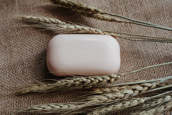 white bar of natural soap on a texture fabric background