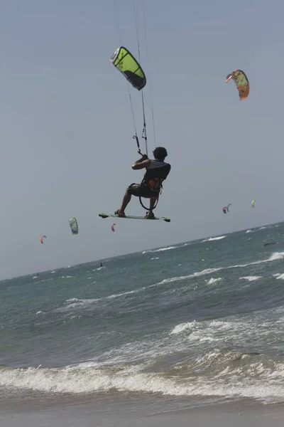 Idrottsman och idrottsman hoppar på vågorna gör kitesurfing — Stockfoto
