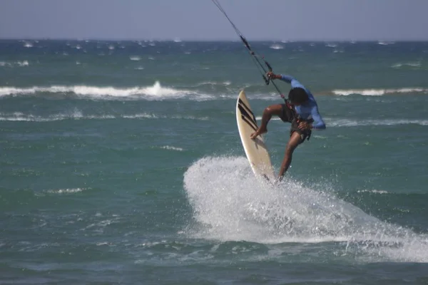 Desportista e atleta saltando sobre as ondas fazendo kitesurf — Fotografia de Stock