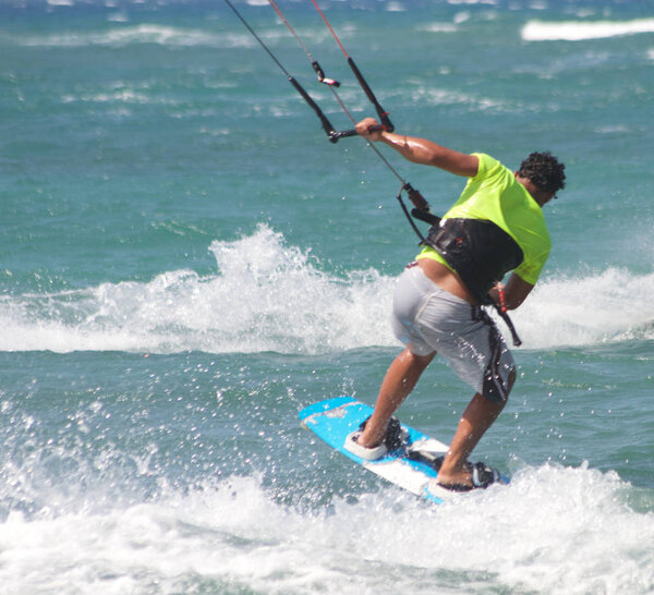sportsman and athlete jumping on the waves doing kitesurfing