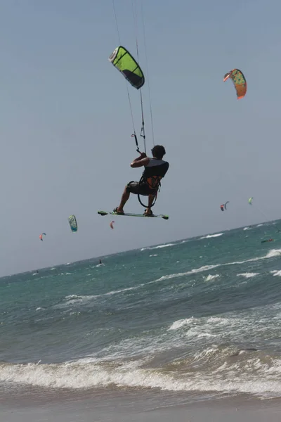 Deportista y atleta saltando en las olas haciendo kitesurf. — Foto de Stock