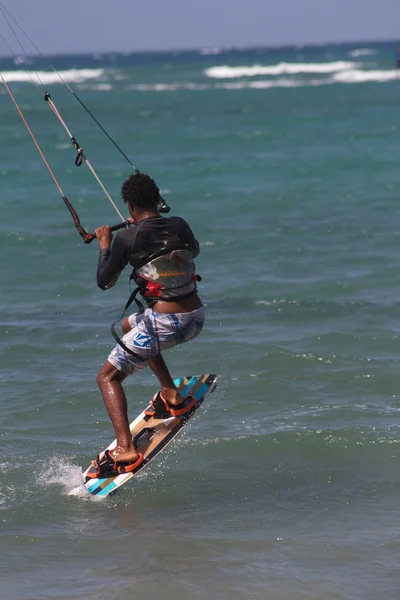 Idrottsman och idrottsman hoppar på vågorna gör kitesurfing — Stockfoto