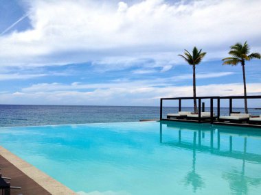 25 Mayıs 2018 'de Dominik Cumhuriyeti' nin Sosua şehrinde havuz kenarındaki merdivenler, palmiye ağaçları ve muhteşem bir dinlenme odası olan güzel bir tatil köyü.