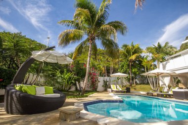 25 Mayıs 2018 'de Dominik Cumhuriyeti' nin Sosua şehrinde havuz kenarındaki merdivenler, palmiye ağaçları ve muhteşem bir dinlenme odası olan güzel bir tatil köyü.