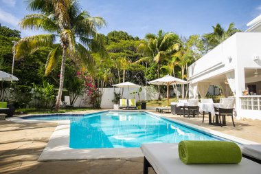 25 Mayıs 2018 'de Dominik Cumhuriyeti' nin Sosua şehrinde havuz kenarındaki merdivenler, palmiye ağaçları ve muhteşem bir dinlenme odası olan güzel bir tatil köyü.