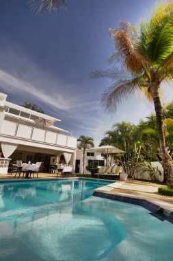 25 Mayıs 2018 'de Dominik Cumhuriyeti' nin Sosua şehrinde havuz kenarındaki merdivenler, palmiye ağaçları ve muhteşem bir dinlenme odası olan güzel bir tatil köyü.