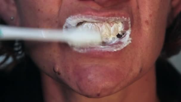 Primer plano de la niña cepillándose los dientes con un cepillo de dientes y espumoso en la boca — Vídeo de stock