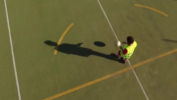 Antenn utsikt o en vacker flicka som tränar på en 5-manna fotbollsplan — Stockvideo
