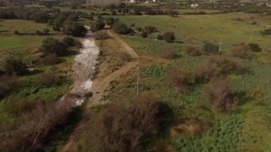 Sardunya 'daki göl ve Coghinas nehrinin, insansız hava aracıyla ağaçlara ve tarımsal alanlara sarılı olduğu hava manzarası.