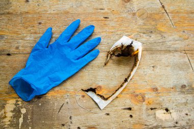 Koronavirüs covid 19 gibi virüslere karşı sterilizasyonun sembolü olarak kullanılan mavi tıbbi eldivenli beyaz koruyucu maske.