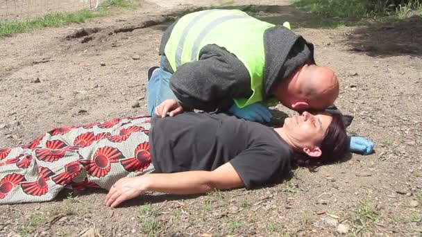 Médico de emergência com jaqueta amarela que intervém para uma reanimação de uma mulher com massagem cardíaca — Vídeo de Stock