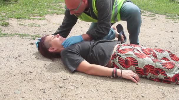 Medico di emergenza con giacca gialla che interviene per la rianimazione di una donna con respirazione bocca a bocca — Video Stock