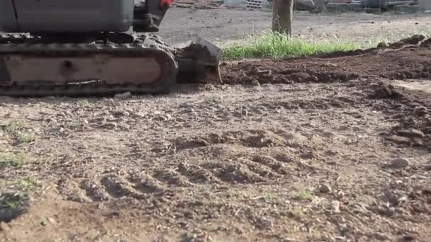 Гусеничные пути перемещения экскаватора в эксплуатации на грунтовой площадке — стоковое видео