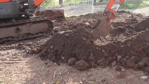 Cubo de excavadora en funcionamiento en un sitio de suciedad — Vídeos de Stock