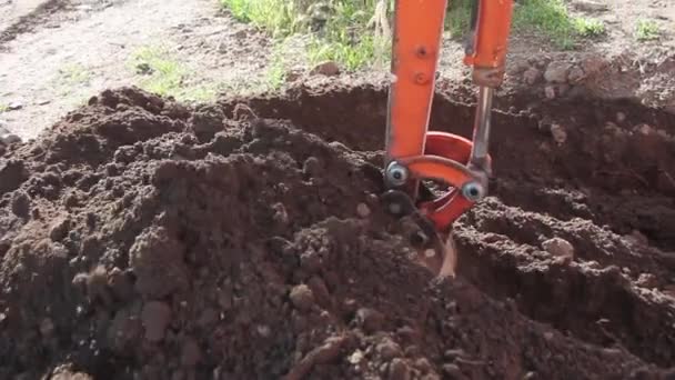 Cubo de excavadora en funcionamiento en un sitio de suciedad — Vídeo de stock