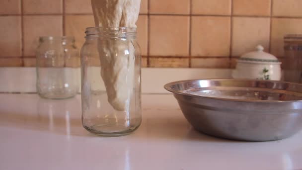 Masa fermentada que se vierte vertiendo lentamente en un frasco transparente para la preparación de la fermentación — Vídeo de stock