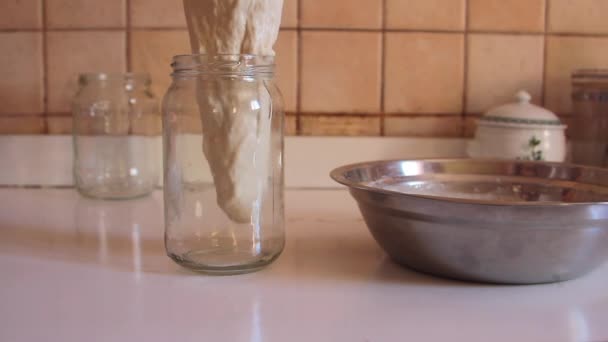 Zuurdesem die wordt gegoten door langzaam in een doorzichtige pot te gieten voor de bereiding van gisting — Stockvideo