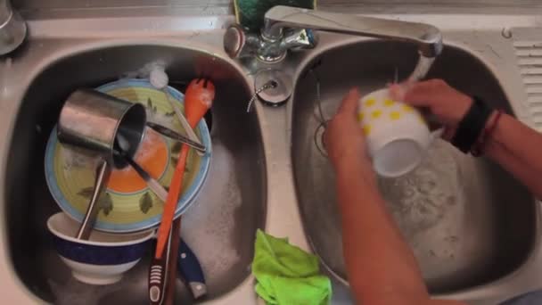 Top view of woman hands washing dishes with pots and cutlery with foam and water — Stock Video