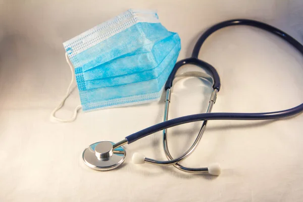 stethoscope with a blue protective healthcare mask on a white background