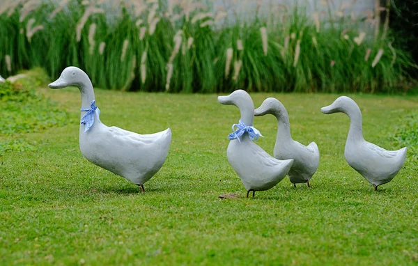 Ördek ailesi heykeli yeşil bir parkta yer.