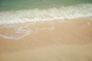 Kum plajı üzerinde mavi okyanus dalgası