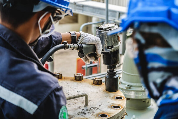 Workers hand holding machine tightening nut, The mechanic is repairing the machine in the factory, Maintenance team in industrial plant