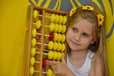little girl with a wreath on her head and an abacus,