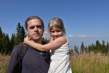 dad and daughter on the background of nature