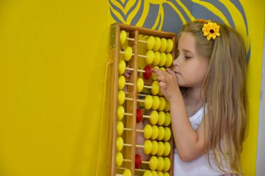 little girl with a wreath on her head and an abacus,