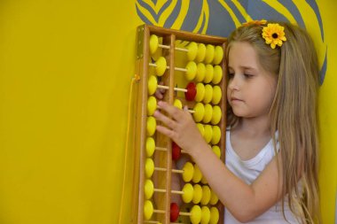 little girl with a wreath on her head and an abacus,