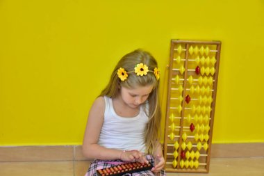 little girl with a wreath on her head and an abacus,