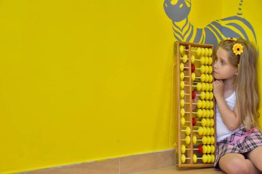 little girl with a wreath on her head and an abacus,