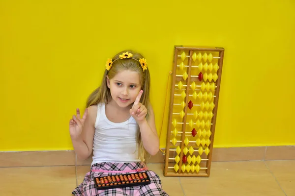 little girl with a wreath on her head and an abacus,