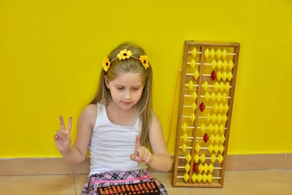 little girl with a wreath on her head and an abacus,